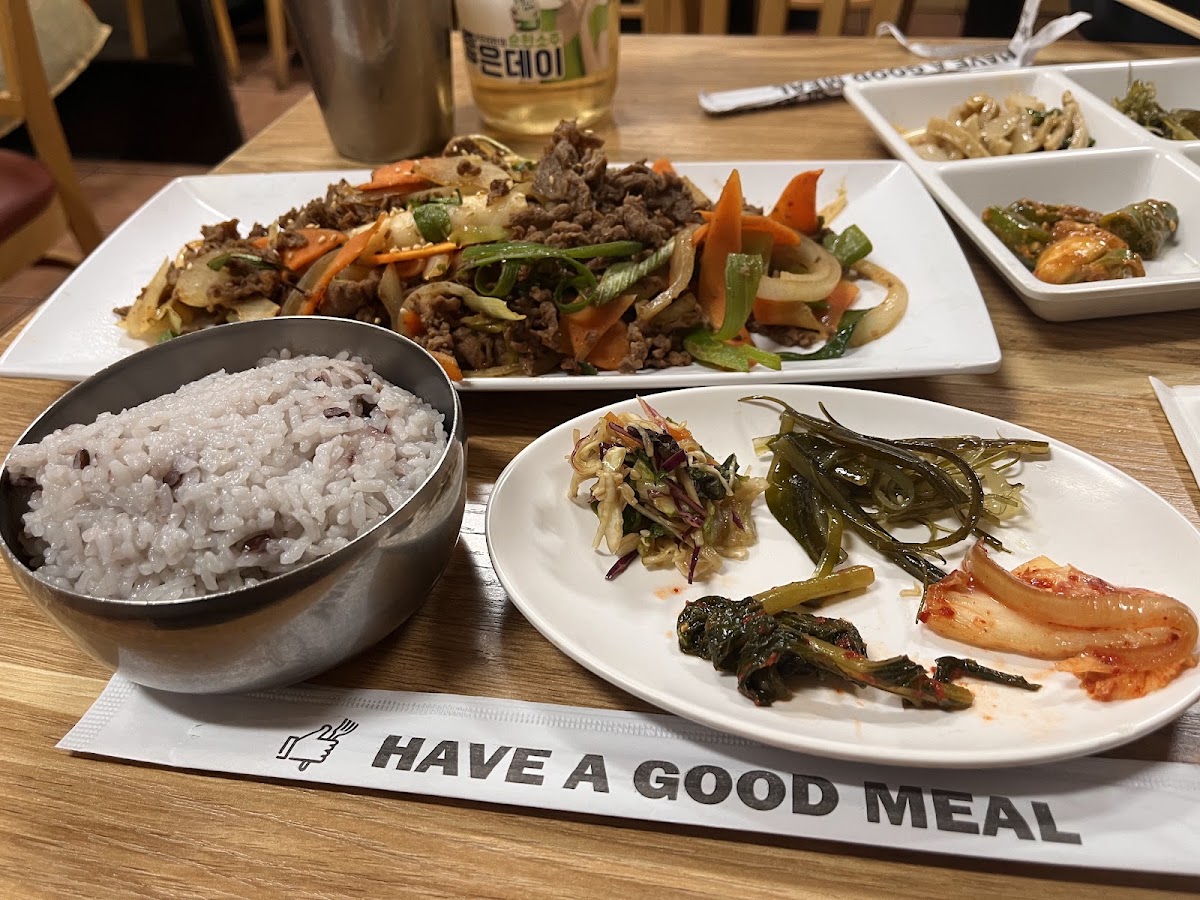 Bulgogi and japchae with a bowl of purple multigrain rice and side dishes