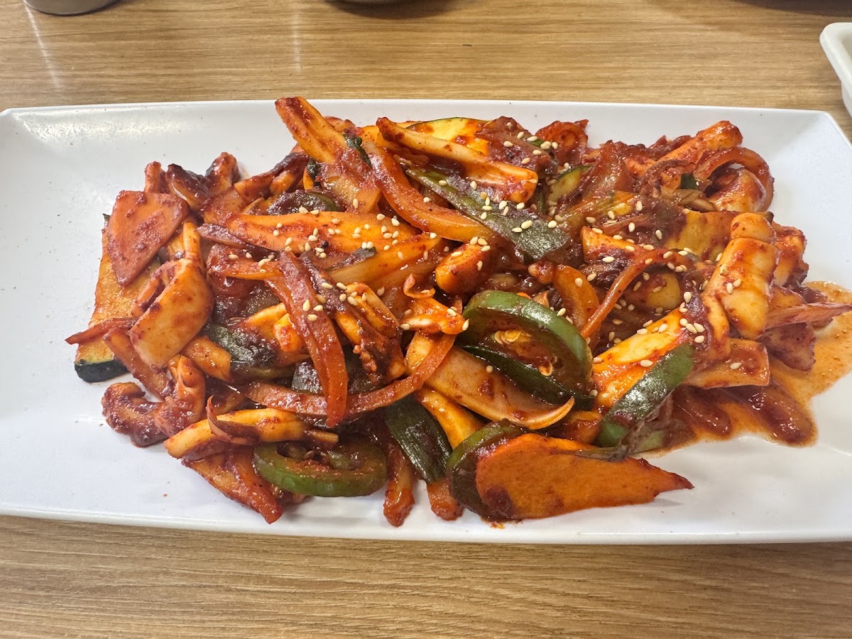A platter of spicy stir fried squid with peppers and onion